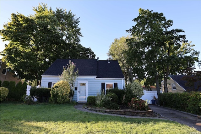 cape cod home featuring a front yard