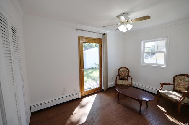 sitting room with baseboard heating, a wealth of natural light, crown molding, and dark hardwood / wood-style floors