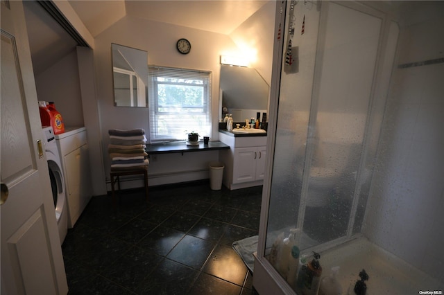 bathroom with vanity, vaulted ceiling, washer and clothes dryer, a shower, and tile patterned flooring