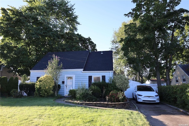 cape cod house featuring a front yard