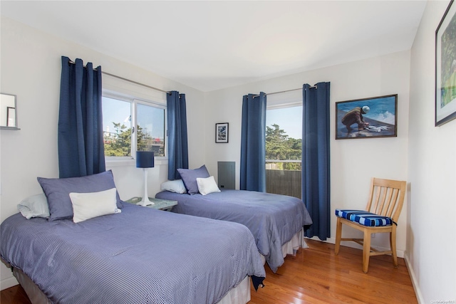 bedroom with multiple windows and wood-type flooring