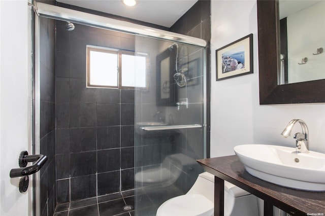 bathroom featuring vanity, a shower with shower door, and toilet