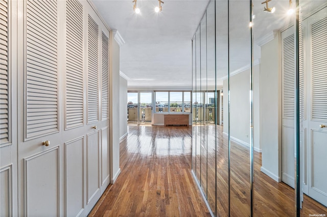 corridor featuring ornamental molding and hardwood / wood-style flooring