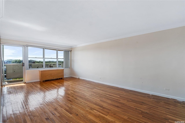 spare room featuring hardwood / wood-style flooring and crown molding