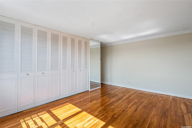 unfurnished bedroom featuring wood-type flooring and ornamental molding