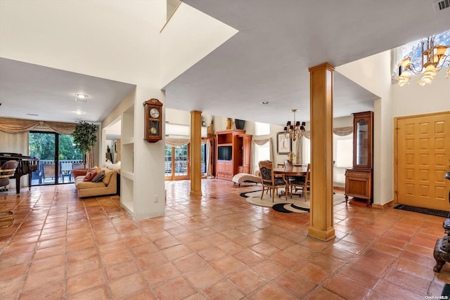 entrance foyer featuring a notable chandelier, light tile patterned floors, and decorative columns