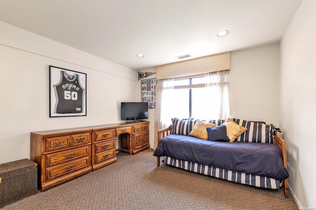 carpeted bedroom featuring built in desk