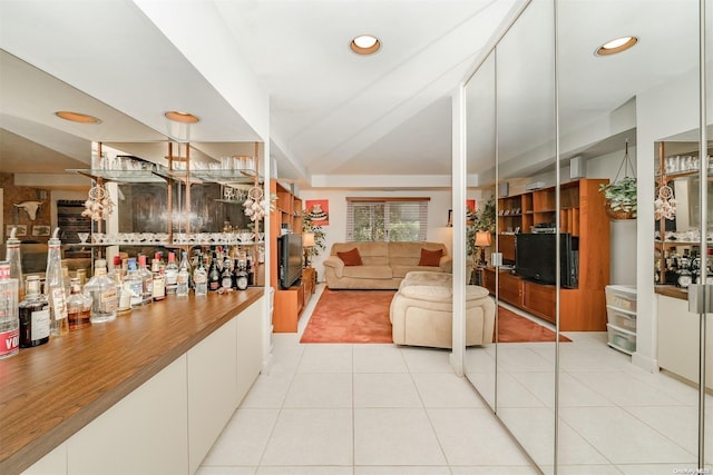 living room featuring light tile patterned floors and indoor bar