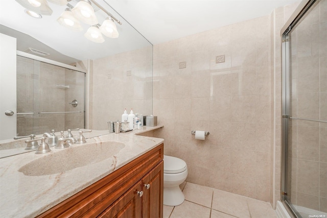 bathroom with tile patterned floors, a shower with shower door, tile walls, and toilet