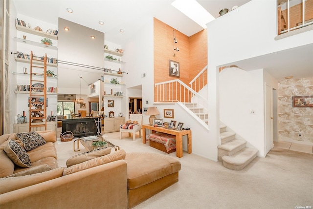 carpeted living room with a towering ceiling and a fireplace