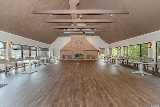 interior space with wood-type flooring, a fireplace, high vaulted ceiling, and track lighting