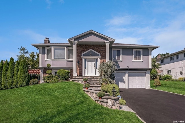 raised ranch featuring a front yard and a garage