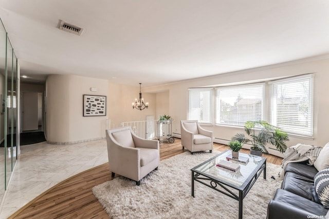 living room with ornamental molding, wood-type flooring, and an inviting chandelier