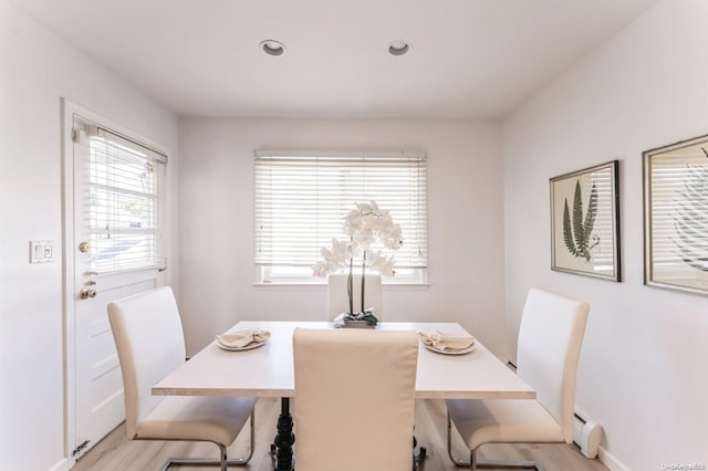 dining space featuring light wood-type flooring and baseboard heating