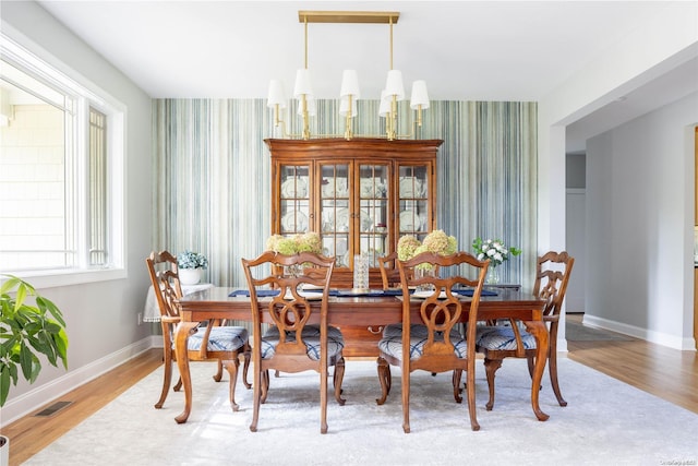 dining area featuring an inviting chandelier and hardwood / wood-style flooring