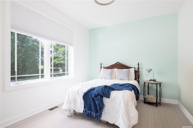 bedroom featuring multiple windows and carpet