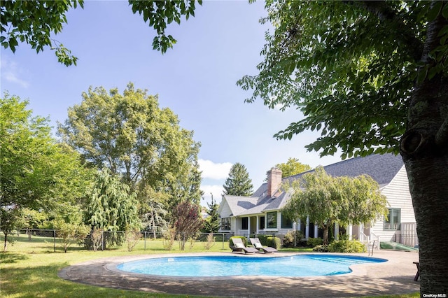 view of pool featuring a lawn