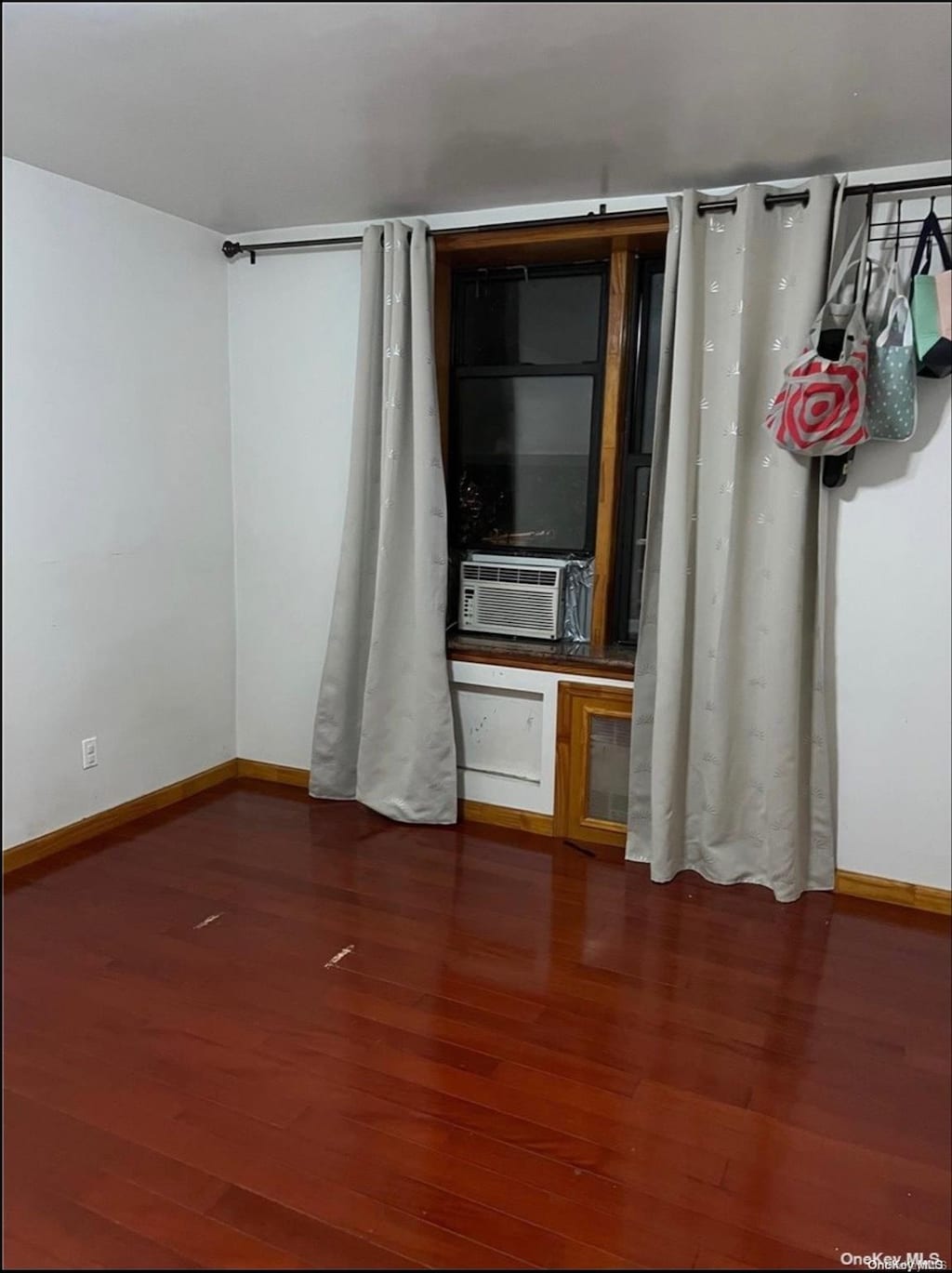 spare room featuring cooling unit and dark wood-type flooring