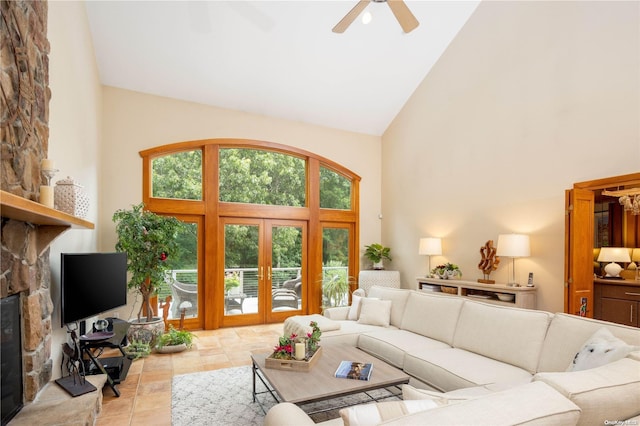 living room featuring ceiling fan, a fireplace, high vaulted ceiling, and french doors