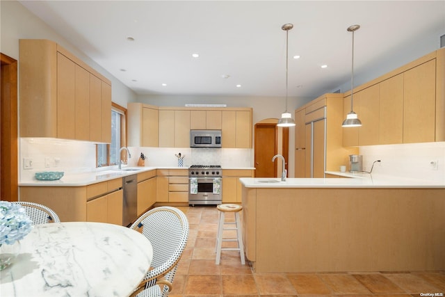 kitchen featuring tasteful backsplash, pendant lighting, light brown cabinets, and stainless steel appliances