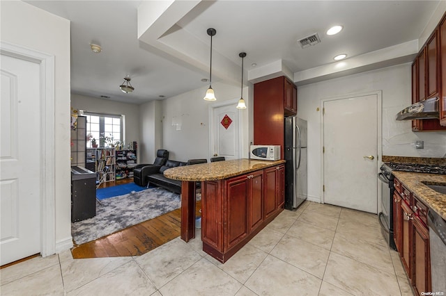 kitchen with hanging light fixtures, a kitchen breakfast bar, light hardwood / wood-style flooring, dark stone counters, and appliances with stainless steel finishes