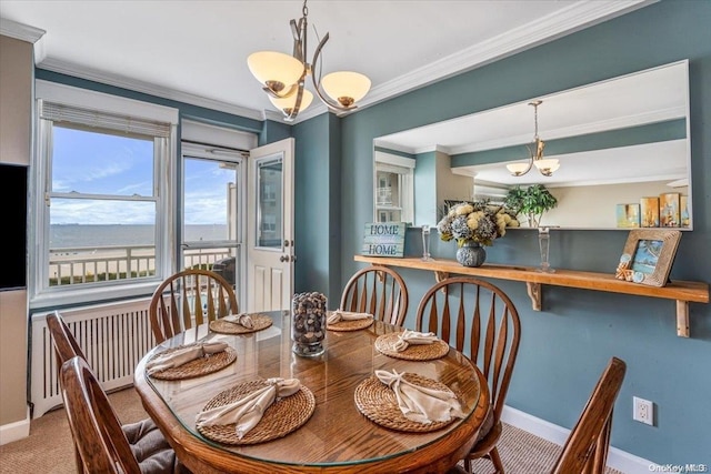 dining area with carpet flooring, an inviting chandelier, radiator, and crown molding