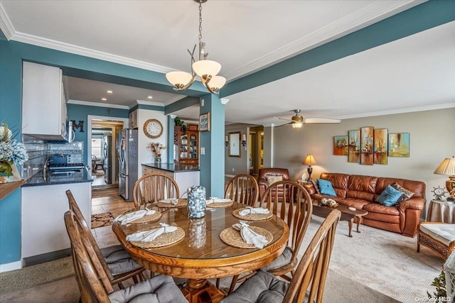 dining room featuring ceiling fan with notable chandelier, ornamental molding, and sink