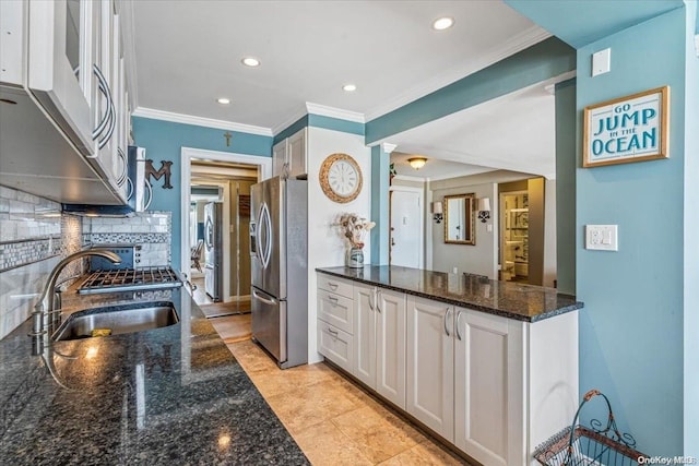 kitchen with sink, dark stone countertops, decorative backsplash, white cabinets, and appliances with stainless steel finishes