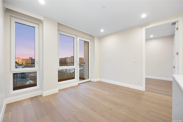 unfurnished room with light hardwood / wood-style floors and a healthy amount of sunlight