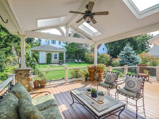 deck featuring ceiling fan, an outbuilding, and a yard