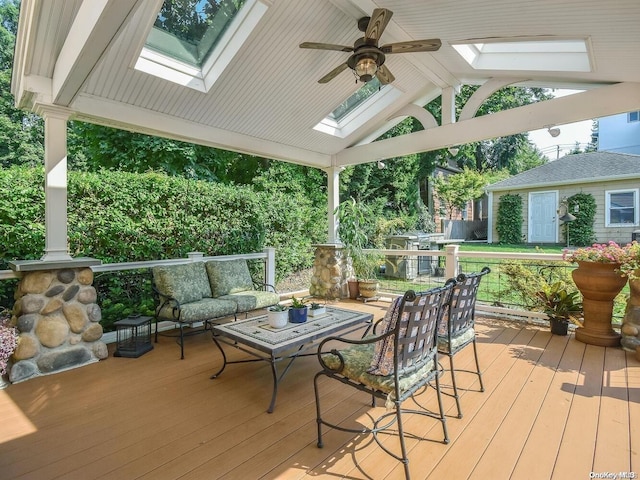 wooden terrace with outdoor lounge area and ceiling fan