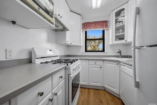 kitchen featuring white appliances, light hardwood / wood-style floors, and white cabinetry