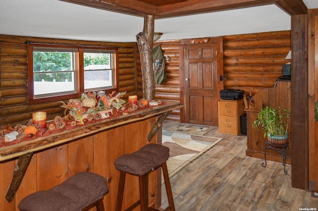 bar with hardwood / wood-style floors and rustic walls