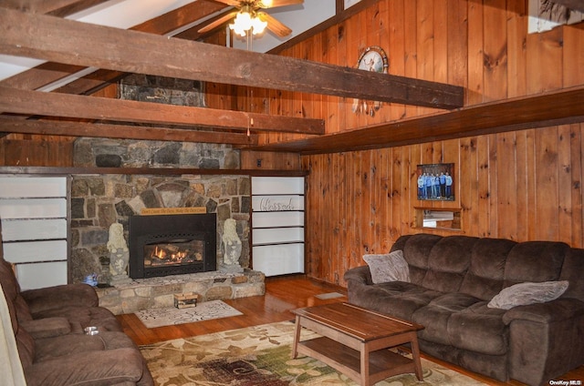 living room featuring vaulted ceiling with beams, ceiling fan, hardwood / wood-style floors, and wooden walls