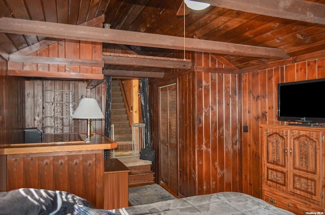 bedroom featuring bar, wooden walls, and vaulted ceiling with beams