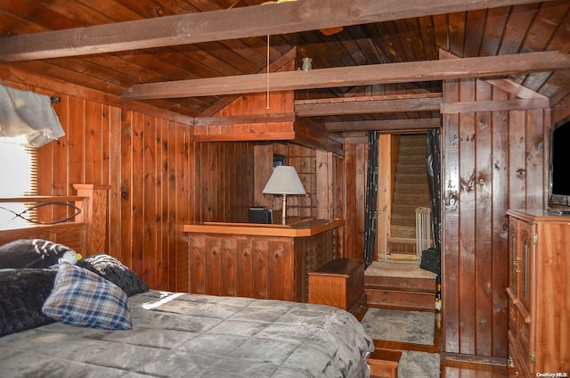 bedroom with lofted ceiling with beams and wood walls