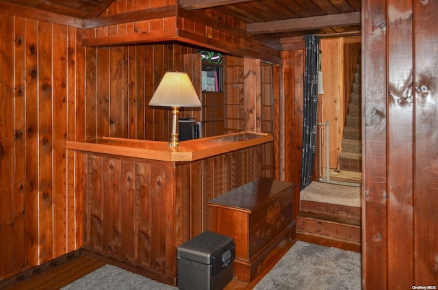 bar featuring beam ceiling, wooden walls, and wooden ceiling