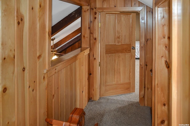 hallway with carpet floors and lofted ceiling