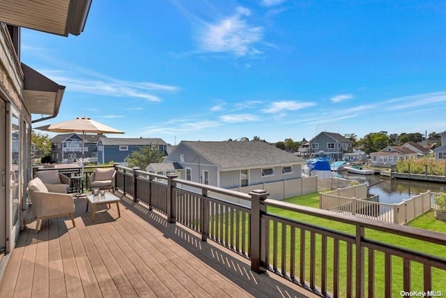 wooden deck with a yard and a water view