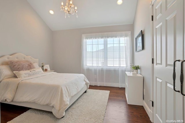 bedroom with a chandelier, dark hardwood / wood-style flooring, and lofted ceiling