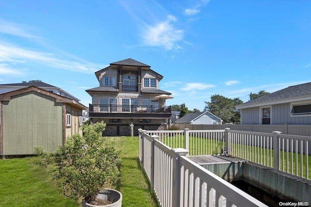 back of property featuring a deck and a lawn