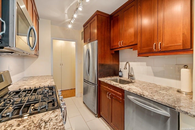 kitchen featuring decorative backsplash, appliances with stainless steel finishes, light stone counters, sink, and light tile patterned floors