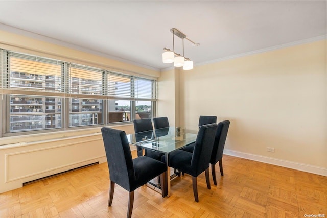 dining space featuring crown molding and light parquet flooring