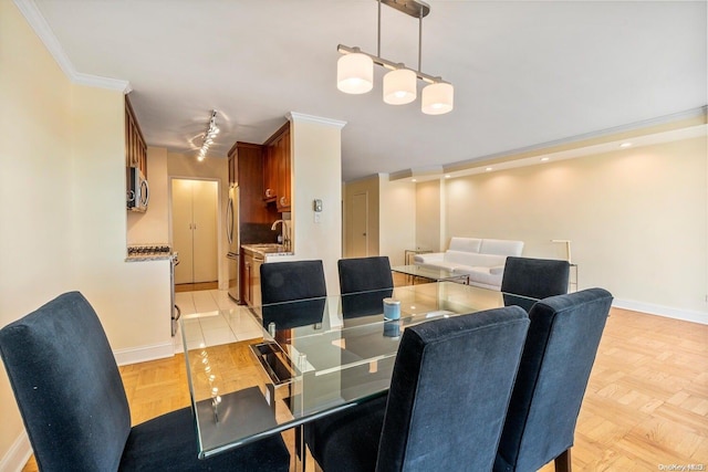 dining area featuring sink, crown molding, and light parquet floors