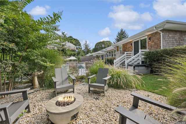 view of patio / terrace featuring a fire pit and a swimming pool