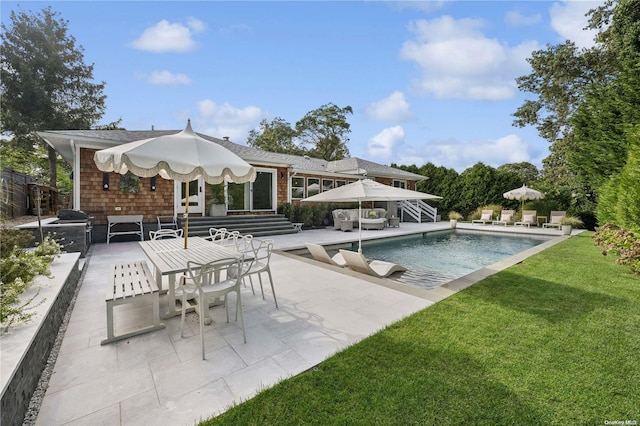 view of pool featuring a lawn and a patio