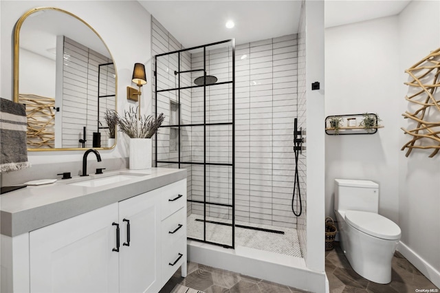 bathroom featuring toilet, vanity, and tiled shower