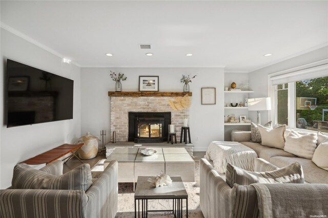 living room featuring a brick fireplace and ornamental molding