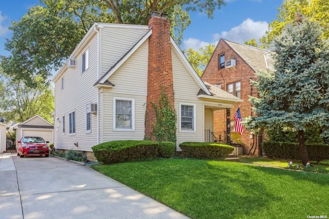 view of front of home featuring an outdoor structure, an AC wall unit, a front yard, and a garage