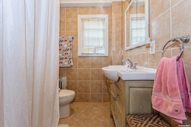 bathroom with tile patterned flooring, vanity, tile walls, and toilet